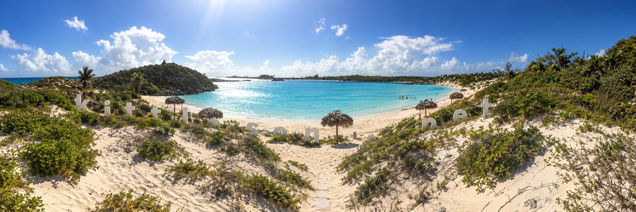 A sandy path through the dunes to a turquoise bay, with the letters kittleson.net standing in the sand.